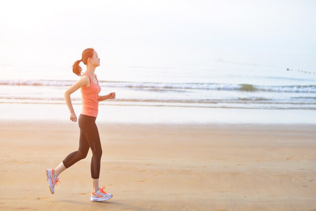 Mujer saludable corriendo en la playa