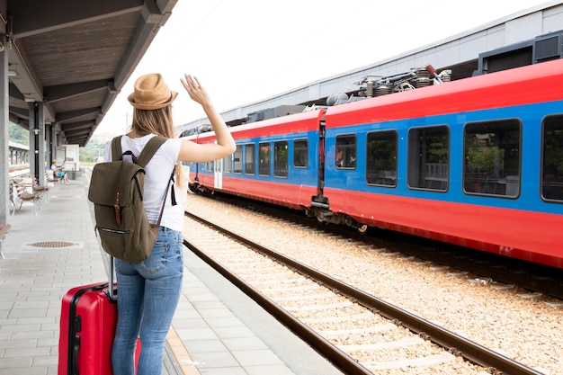 Mujer saludando al tren desde atrás