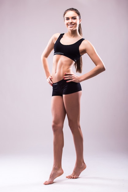 Mujer sana activa segura satisfecha en ropa deportiva con las manos en las caderas