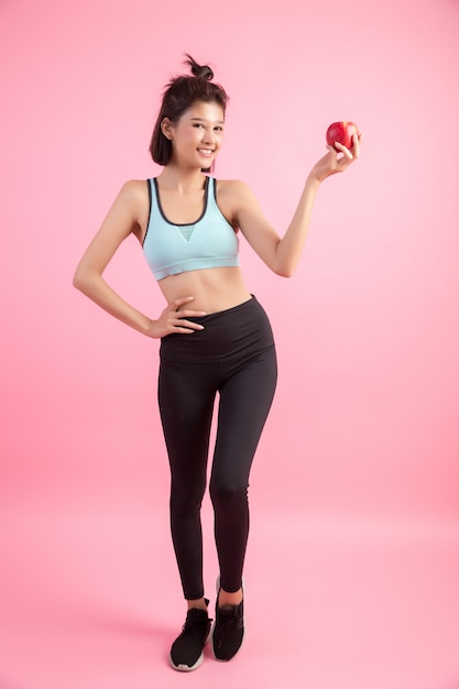 Mujer sana del deporte que sostiene una manzana roja