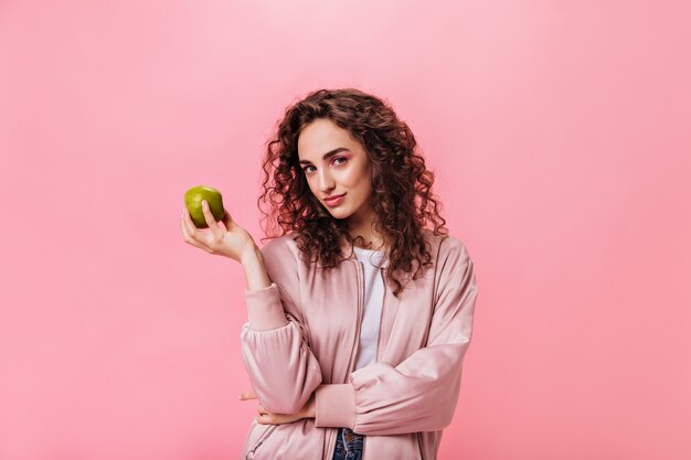 Mujer sana mirando a la cámara y sosteniendo Apple