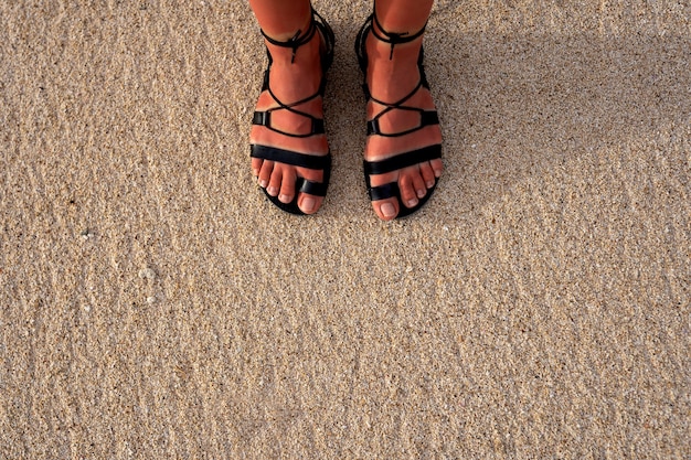 Mujer con sandalias romanas en la playa