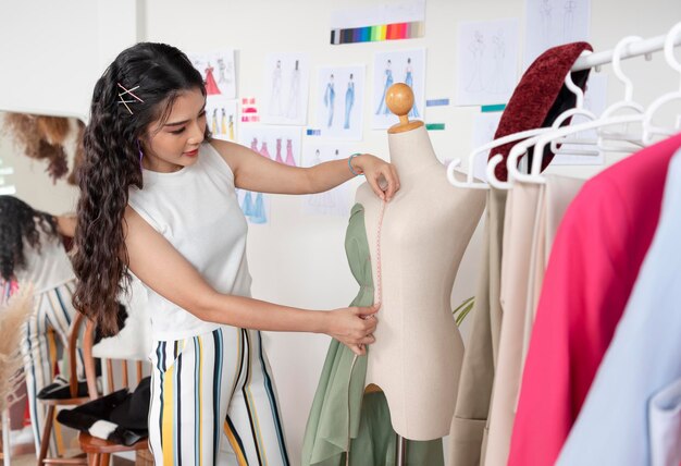 Mujer sastre asiática trabajando en ropa en taller de sastrería