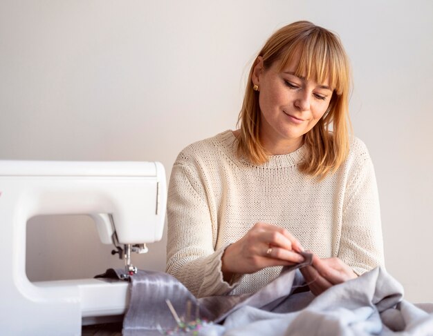 Mujer de sastre con hilo y aguja para coser