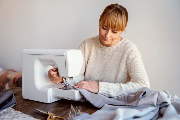 Mujer de sastre con máquina de coser