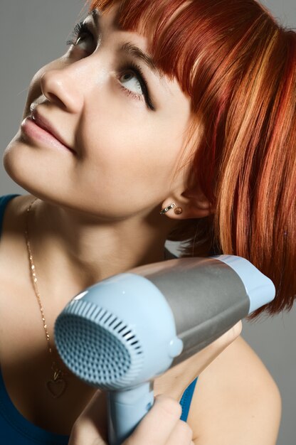 Mujer con secador de pelo y un cepillo para el cabello