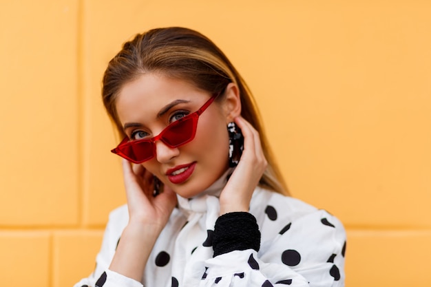 Mujer seductora en elegante traje casual posando con bolso de cuero negro de lujo.