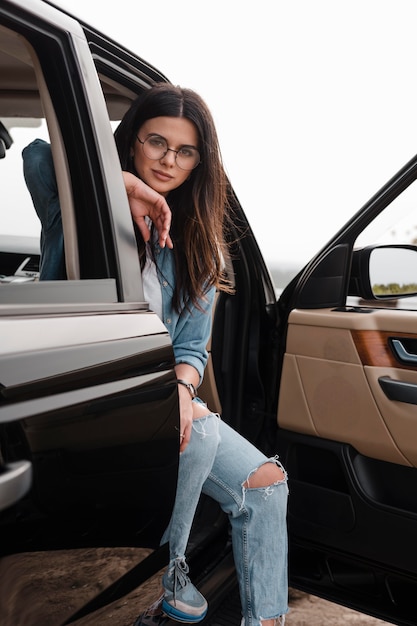 Mujer seductora con gafas viajando sola en coche