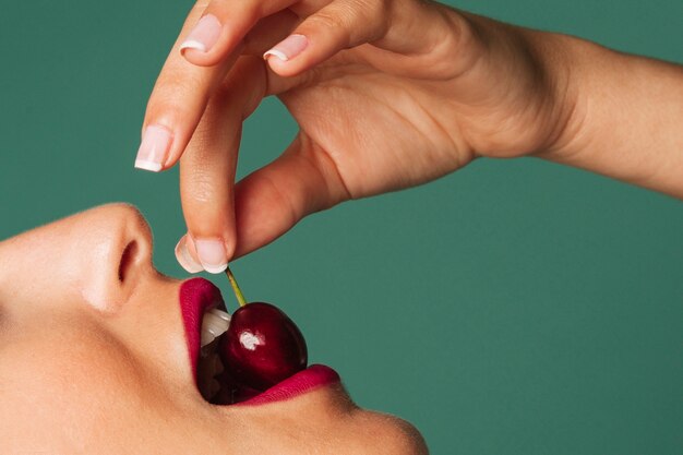 Mujer seductora mordiendo una cereza