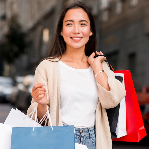 Mujer seductora posando con bolsas de la compra y sesión de venta