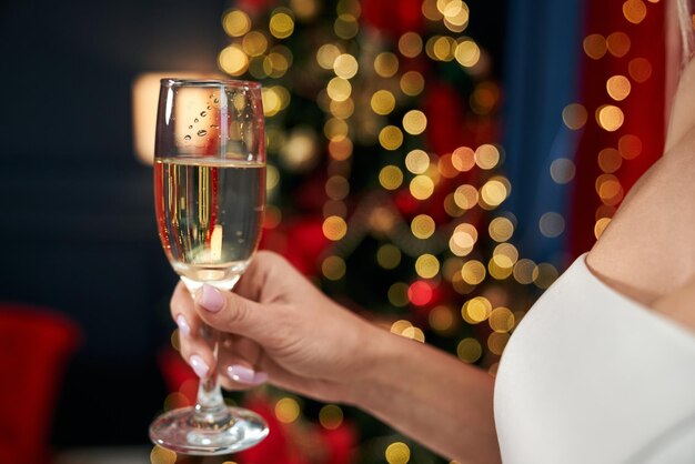 Mujer seductora rubia sosteniendo una copa de champán animando