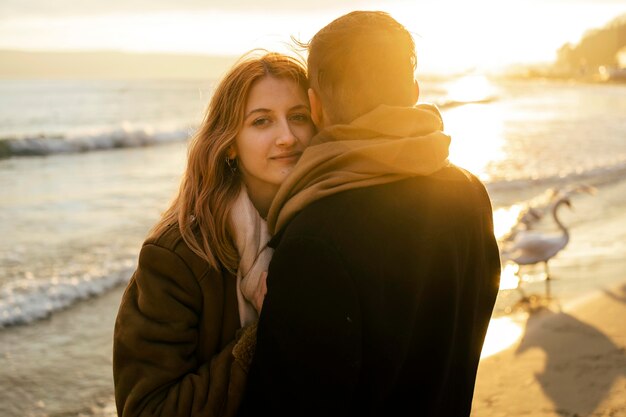 Mujer seductora con su novio en la playa en invierno