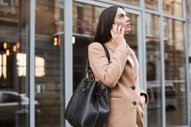 Mujer segura hablando por teléfono afuera