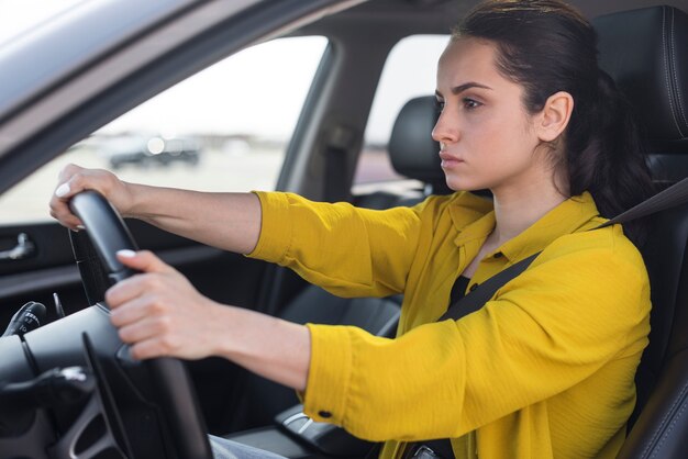 Mujer segura de lado conduciendo