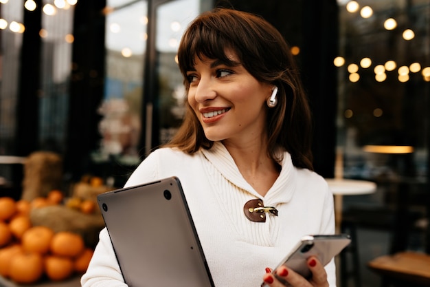 Foto gratuita mujer segura moderna con cabello castaño con laptop