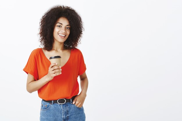 Mujer segura con peinado afro posando en el estudio