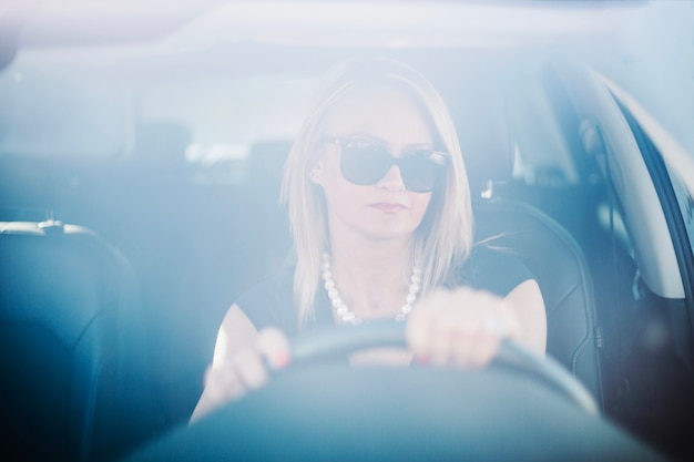 Mujer segura que conduce el coche