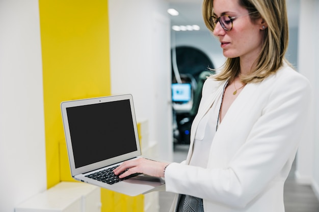 Foto gratuita mujer segura que usa la computadora portátil en oficina