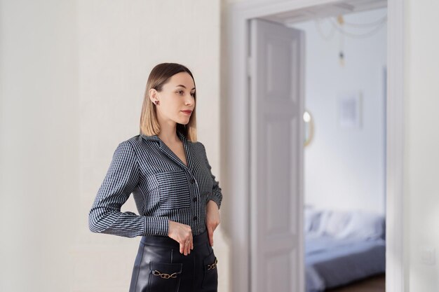 Mujer segura de sí misma mirando su reflejo en el espejo interior Hermoso diseño de interiores