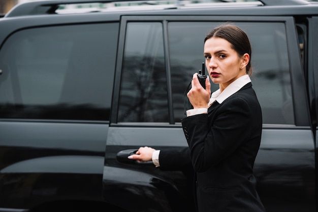 Mujer de seguridad frente a auto