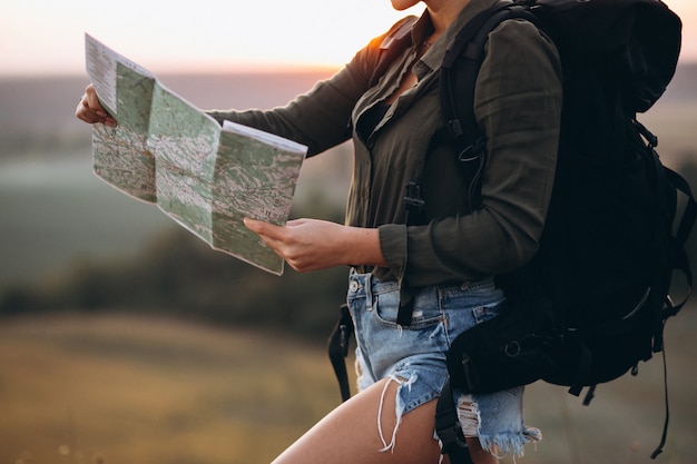 Mujer de senderismo en las montañas y mirando en el mapa