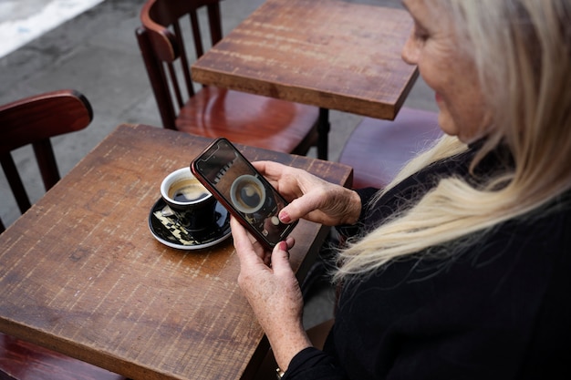 Mujer senior de alto ángulo con teléfono inteligente