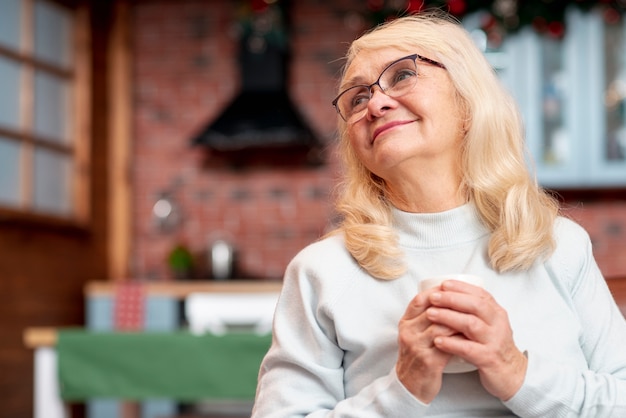 Mujer senior de ángulo bajo bebiendo té