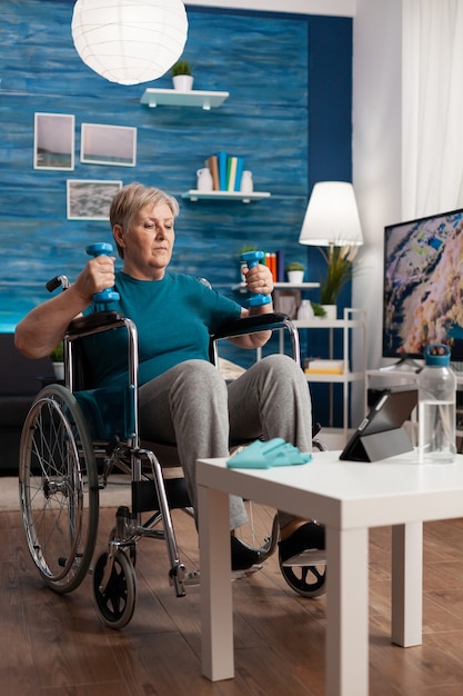 Mujer senior discapacitados sosteniendo pesas entrenador haciendo ejercicio de brazos