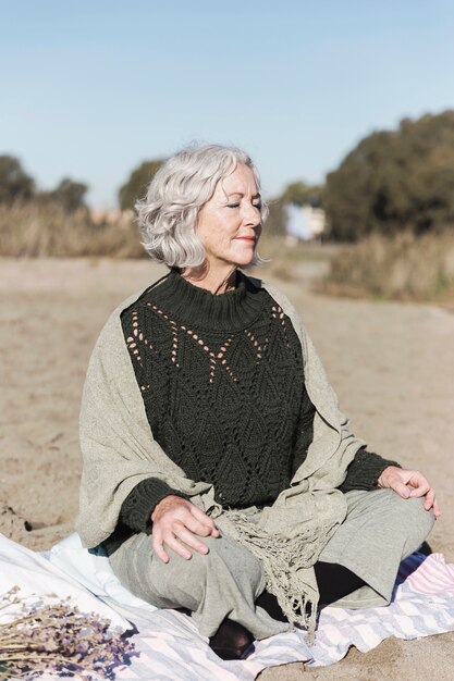 Mujer senior feliz meditando