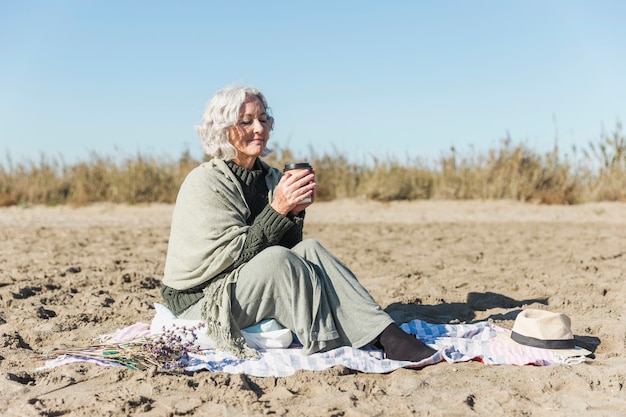 Foto gratuita mujer senior pacífica con café