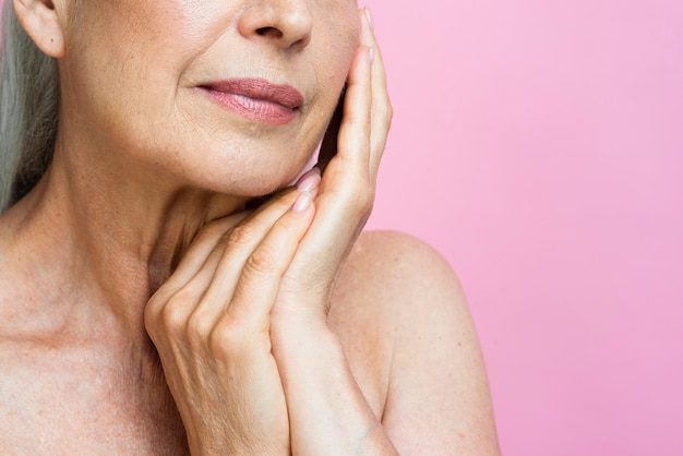 Mujer senior de primer plano con fondo rosa