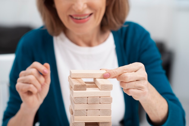 Mujer senior de primer plano jugando jenga