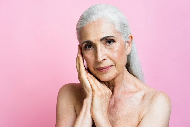 Mujer senior segura con fondo rosa