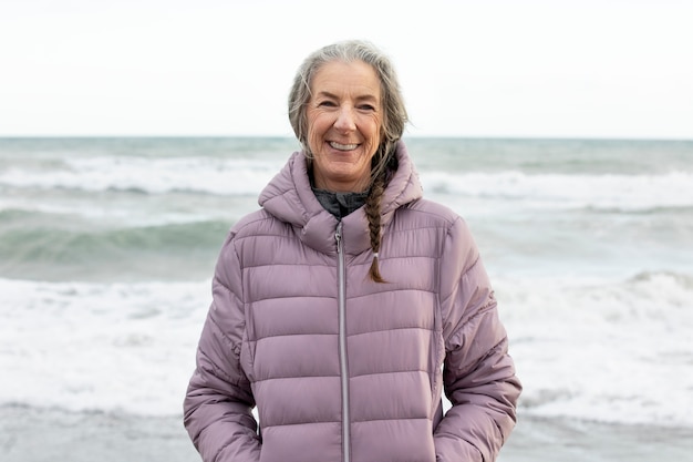 Foto gratuita mujer senior sonriente de tiro medio en la playa