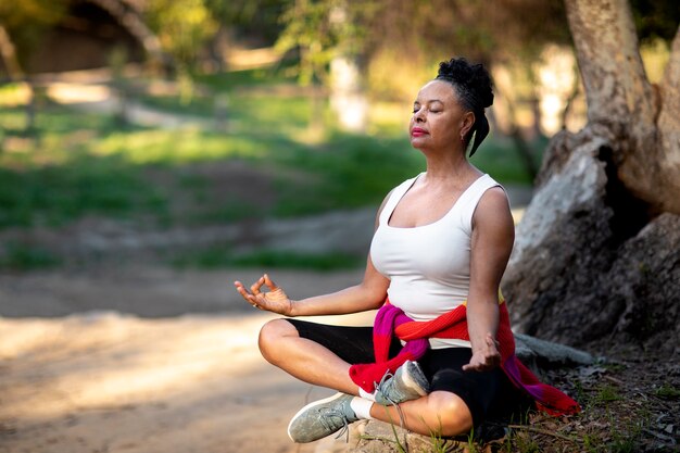 Mujer senior de tiro completo meditando