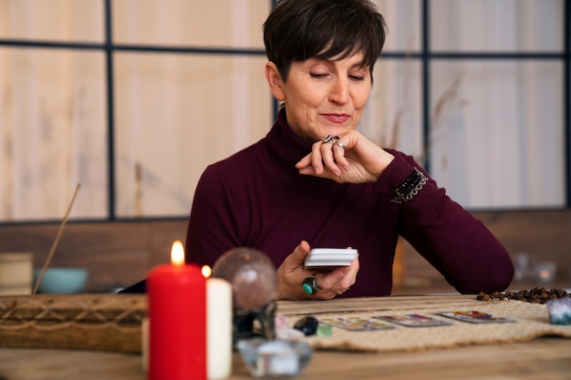 Foto gratuita mujer senior de tiro medio leyendo tarot