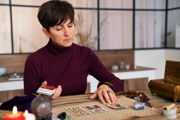 Mujer senior de tiro medio leyendo tarot