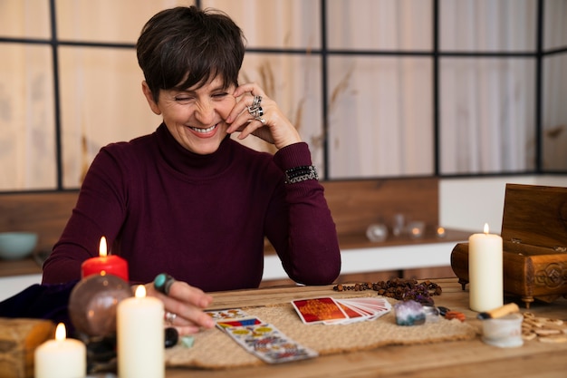 Foto gratuita mujer senior de tiro medio leyendo tarot