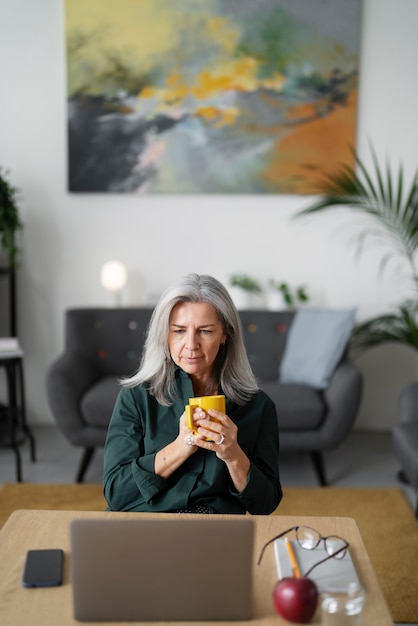 Mujer senior de tiro medio sosteniendo taza