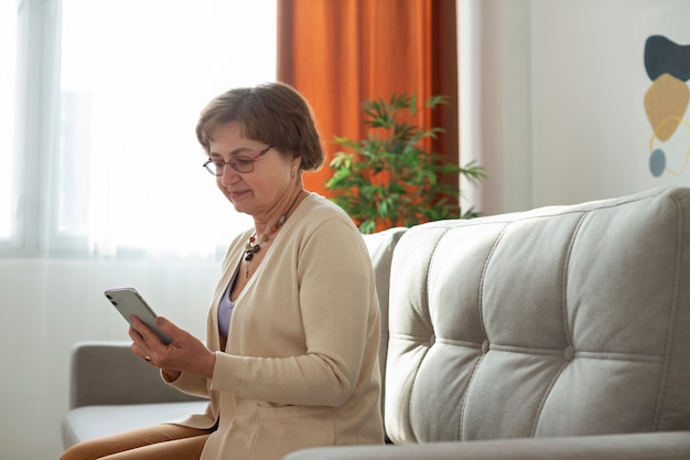 Foto gratuita mujer senior de tiro medio con teléfono