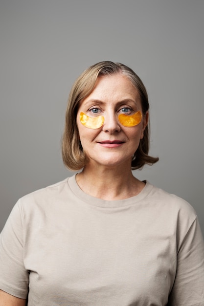 Mujer senior de tiro medio usando parches en los ojos