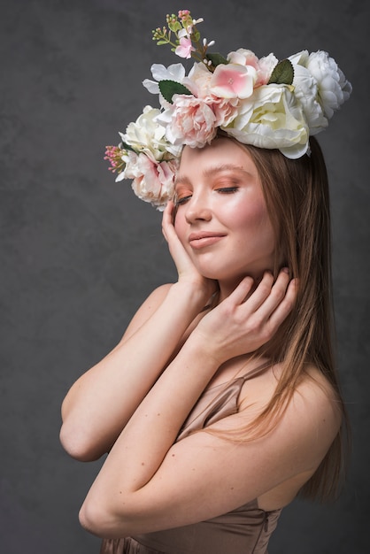 Mujer sensual alegre joven en vestido con la guirnalda hermosa de la flor