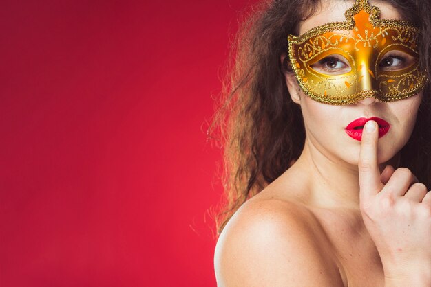 Mujer sensual atractiva en máscara de oro
