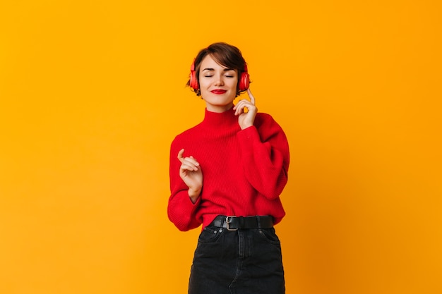 Mujer sensual escuchando música con los ojos cerrados