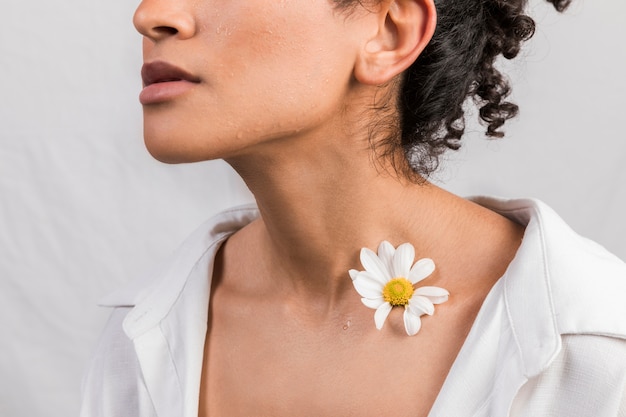 Mujer sensual con flor en el cuello.