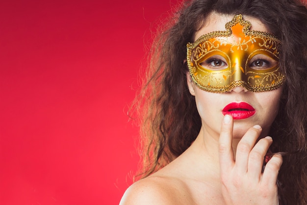 Mujer sensual en máscara de oro del carnaval