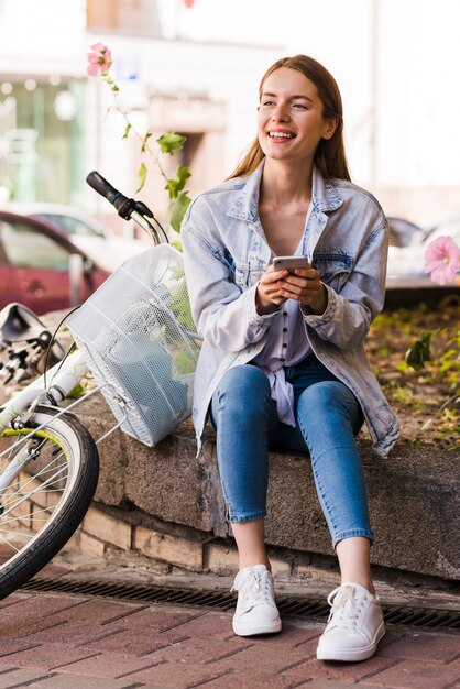 Mujer sentada al lado de su bicicleta