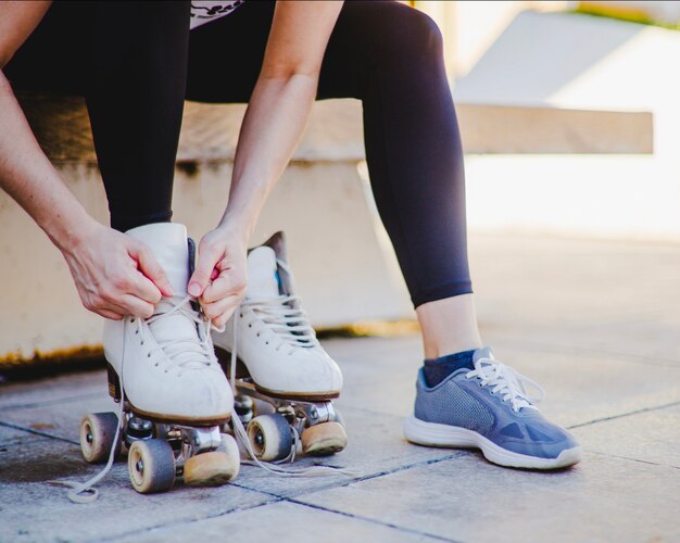 Mujer sentada atando patines de ruedas