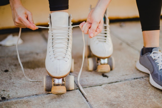 Mujer sentada atando patines de ruedas