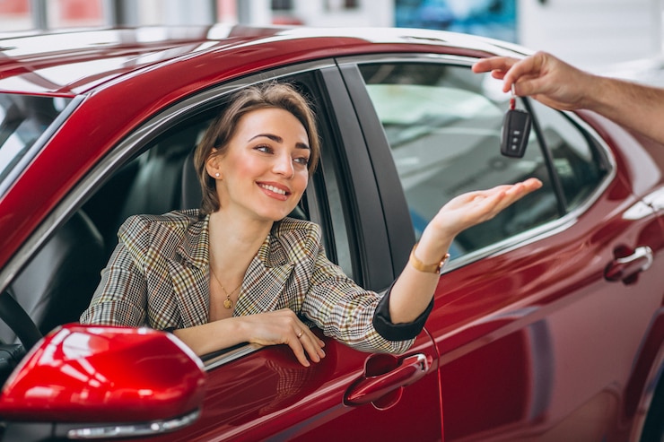 Foto gratuito mujer sentada en auto rojo y recibiendo llaves